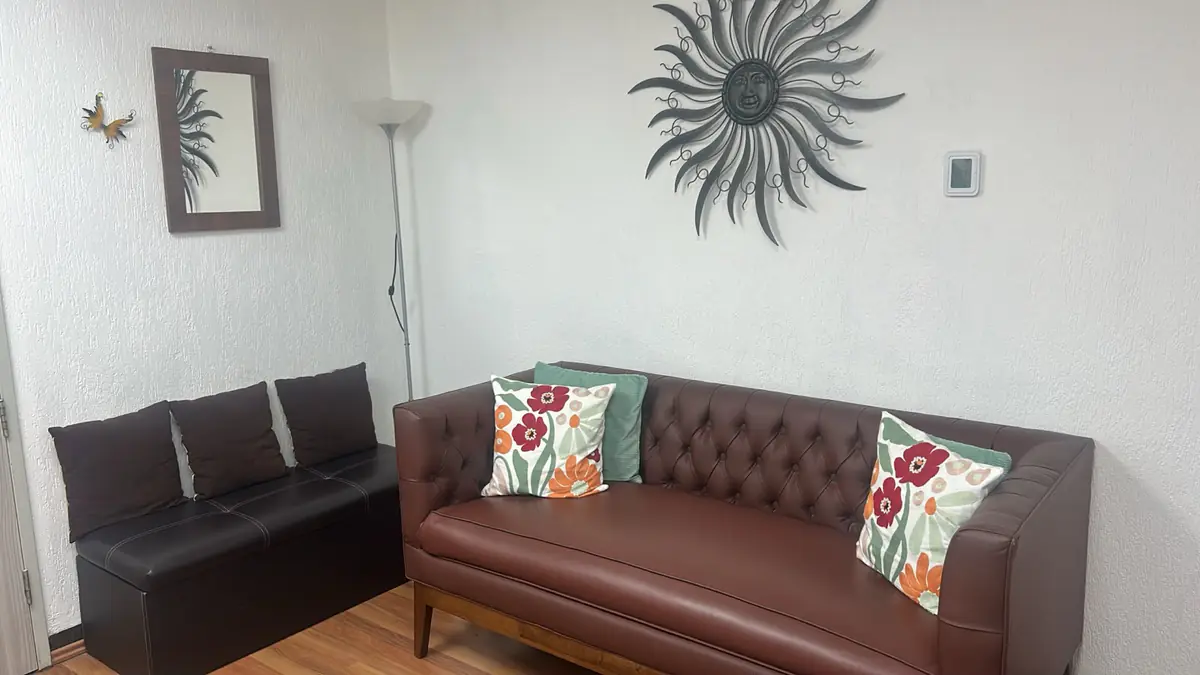 Sala de espera con sillón de piel del consultorio de medicina interna de la Dra. Mia Vázquez en el Pedregal