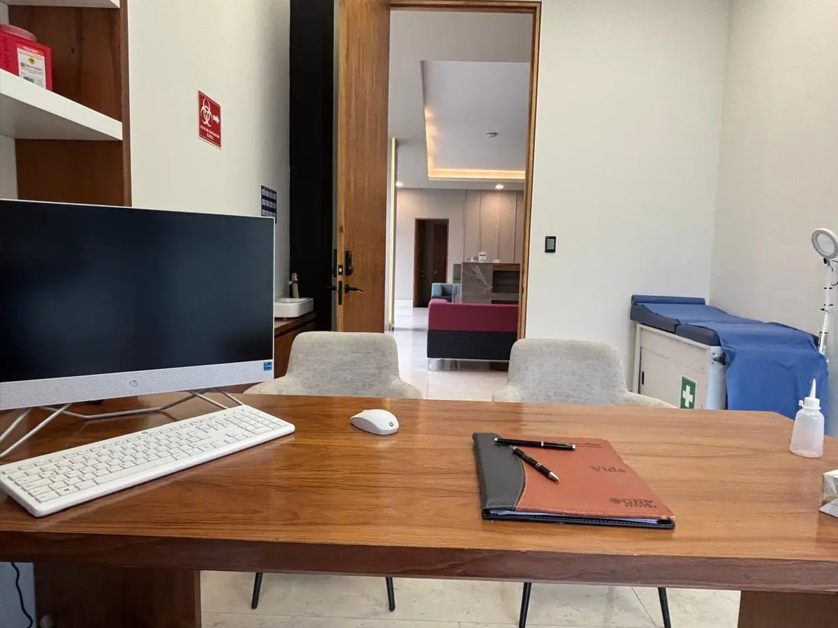 Consultorio de medicina interna en Tlalpan con escritorio, computadora y camilla de exploración
